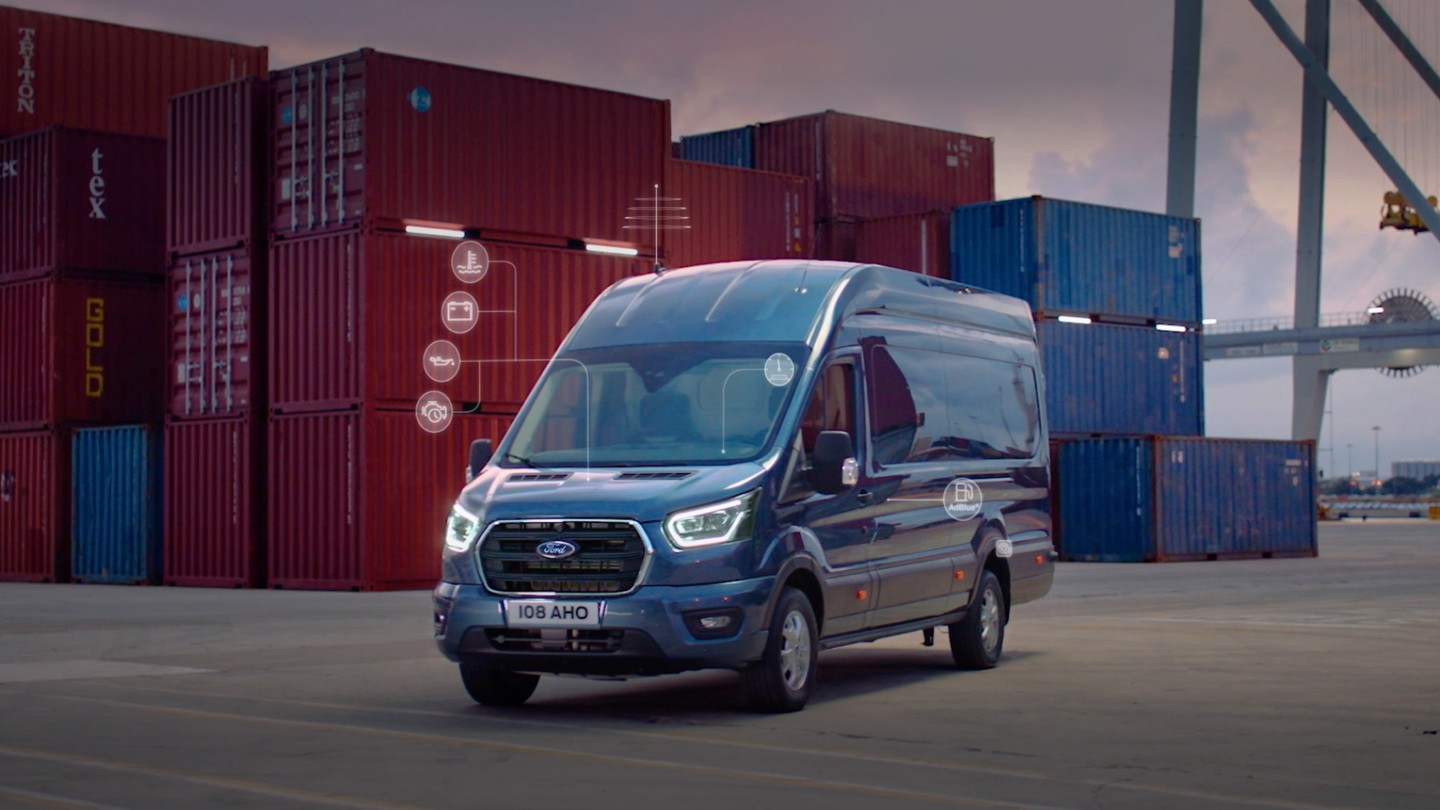 Blue Ford Transit by shipping containers